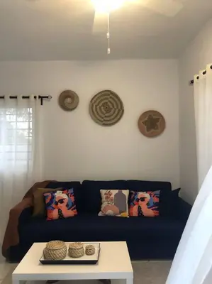 a living room with a blue couch and a table at Sol Caribe 101 Bayahibe con linda piscina! in Bayahibe