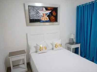 a bedroom with two beds and blue curtains at Elegant and confortable close to Boca Chica Beach in Boca Chica