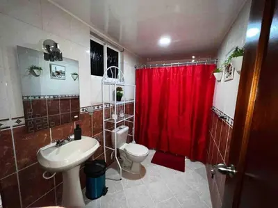 a bathroom with a toilet and a red shower curtain at Entire apartment Tu Nido De Amor 2 Santo Domingo West in Santo Domingo
