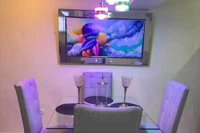 a dining room with a glass table and a tv at Entire apartment Tu Nido De Amor 2 Santo Domingo West in Santo Domingo