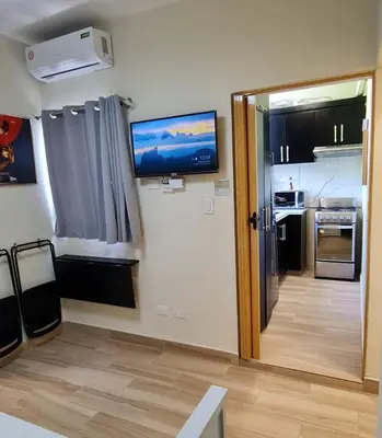 a room with a kitchen and a television on the wall at Apartaestudio en el centro de Puerto Plata in San Felipe de Puerto Plata