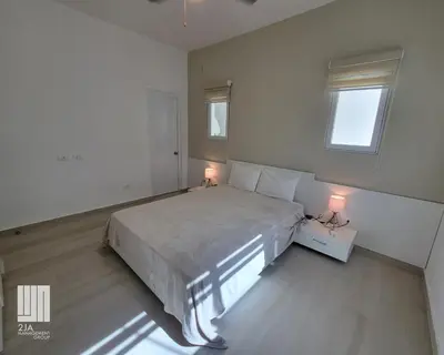 a bedroom with a large bed and two lamps at 2JA Management Group - Condos White Hill in Sosúa