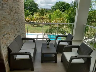 a patio with chairs and a table and a pool at Hard Rock at Cana Pearl 1 by Unwind Properties in Punta Cana