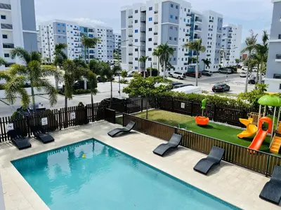an apartment pool with a slide and a playground at Rustic Elegance St in Santiago de los Caballeros