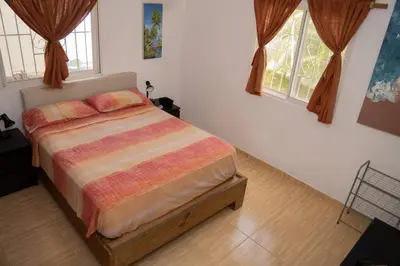 a bedroom with a bed in a room with windows at Villa Caribe in Bayahibe