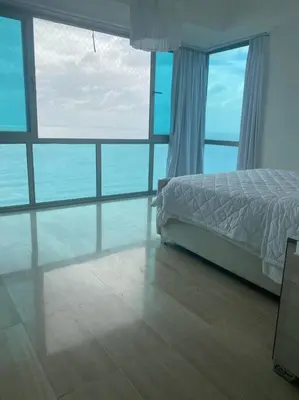 a bedroom with a bed and a view of the ocean at Habitación Privada con vista al mar Ámbar, Malecon Santo Domingo in Santo Domingo