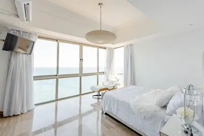 a bedroom with a bed and a large window at Habitación Privada con vista al mar Ámbar, Malecon Santo Domingo in Santo Domingo