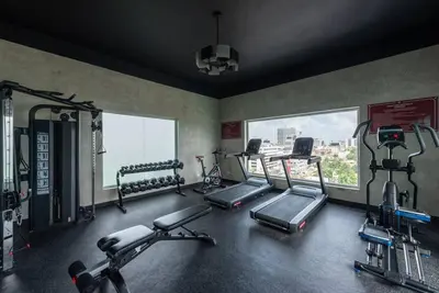 a gym with several tread machines in a room with windows at Stunning infinity pool apartment in Santo Domingo