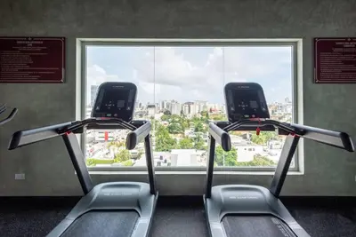 a gym with two cardio machines in front of a window at Stunning infinity pool apartment in Santo Domingo