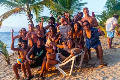a group of people posing for a picture on the beach at Hostel 23 in Las Terrenas