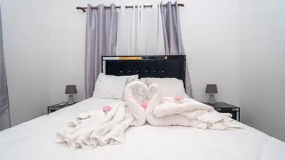 two swans wrapped in towels sitting on a bed at Sky Blue in Jarabacoa