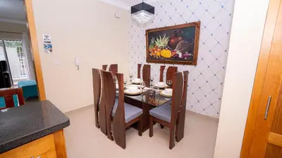 a dining room table with chairs and a painting on the wall at Sky Blue in Jarabacoa
