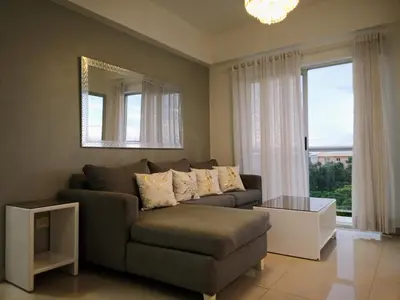 a living room with a couch and a mirror at Confortable apto. en Boca Chica in Boca Chica