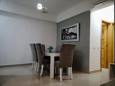 a dining room with a white table and chairs at Confortable apto. en Boca Chica in Boca Chica