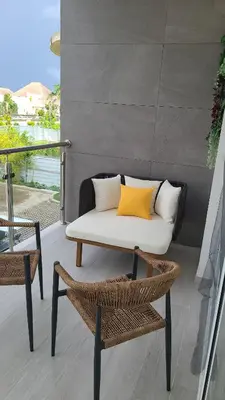 a table and chairs on a balcony with a couch at Hard Rock Punta Cana Luxe Apartment 2BR Coral Bay by BTC Crypto Group in Punta Cana