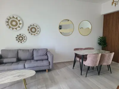 a living room with a couch and a table and mirrors at Hard Rock Punta Cana Luxe Apartment 2BR Coral Bay by BTC Crypto Group in Punta Cana