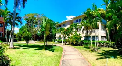 a resort with palm trees and a walkway at Paradis Mimies Dominican Bay in Boca Chica