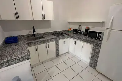 a kitchen with white cabinets and a white refrigerator at Caribe Campo Sosua in Sosúa
