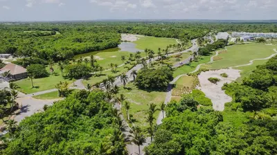 an aerial view of a golf course with palm trees at Hard Rock Getaway • 2BR with Golf + Pool Views in Punta Cana