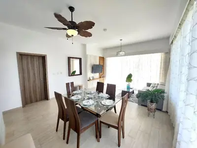 a dining room with a table with chairs and a ceiling fan at Hard Rock Getaway • 2BR with Golf + Pool Views in Punta Cana
