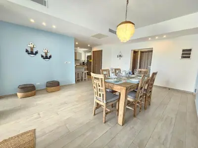 a dining room with a wooden table and chairs at 2BR Beach Condo • Prime Location Across Hard Rock in Punta Cana