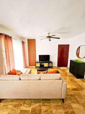 a living room with a couch and a ceiling fan at Madonna1 pool beach los corales Arenas de Bavaro in Punta Cana