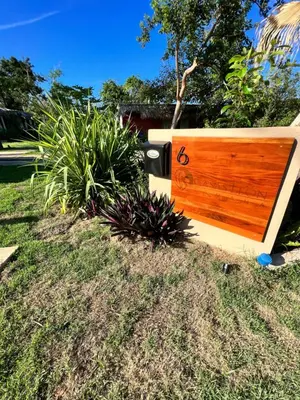 a wooden bench sitting in the grass with plants at CASAS LEON Casita de playa #2 in Santa Bárbara de Samaná