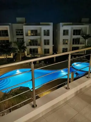 a metal railing with blue pools in front of a building at Confortable apartamento en Playa Nueva Romana in San Pedro de Macorís