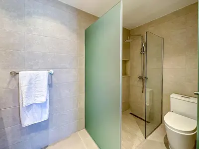 a bathroom with a toilet and a glass shower at Fantastic Penthouse at Golf Course in Punta Cana