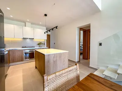 a kitchen with white cabinets and a table and chairs at Fantastic Penthouse at Golf Course in Punta Cana