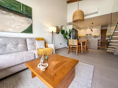 a living room with a couch and a table at Fantastic Penthouse at Golf Course in Punta Cana