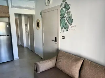 a living room with a couch and a door at Komfortowy Apartament z 4 Basenami i Pięknym Ogrodem, Estrella Dominicus-Bayahibe in Bayahibe