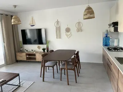 a kitchen and dining room with a table and chairs at Komfortowy Apartament z 4 Basenami i Pięknym Ogrodem, Estrella Dominicus-Bayahibe in Bayahibe