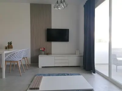 a living room with a tv on a wall at Star of Caribbean- Estrella Dominicus Bayahibe in Bayahibe
