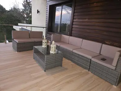 a patio with a couch and a table on a house at Luxury Mountain villa, Jarabacoa villa vargas in Concepción de La Vega