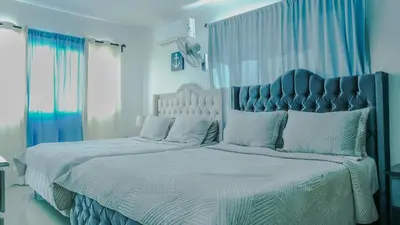 a bedroom with a large bed with a blue headboard at Rooftop with Pool, La Romana, Villa Doña Julia, At Paula Isabel in La Romana