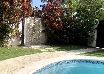 a swimming pool in a yard next to some bushes at Las Terrenas Villa- King Bed, Beaches & Dining in Las Terrenas