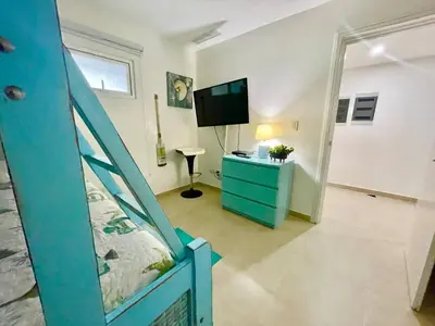 a bedroom with a bunk bed and a tv in a room at Enjoy beach life at this gated in Juan Pedro
