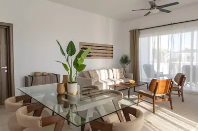 a living room with a glass table and chairs at Modern & relaxing penthouse Lake and Golf View in Punta Cana