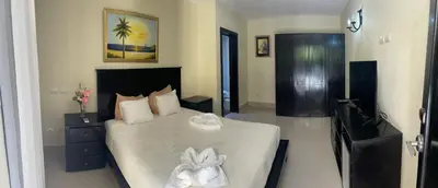 a bedroom with a large bed with white sheets at Hotel Plaza Brisas in Punta Cana