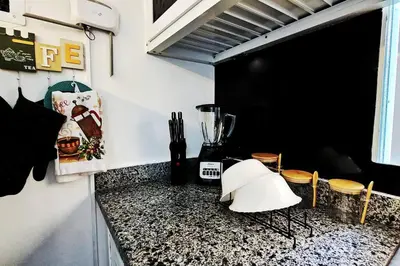 a kitchen with a counter with a blender and stools at Apartamento acogedor Ashmi in Santiago de los Caballeros