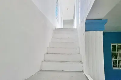 a stairway with white stairs in a room at Apartamento acogedor Ashmi in Santiago de los Caballeros