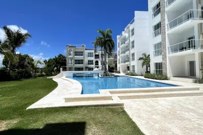 a swimming pool in front of a building at Beautiful Penthouse with private elevator in Hard Rock Golf in Punta Cana