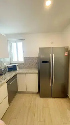 a kitchen with a stainless steel refrigerator in a room at Beautiful Penthouse with private elevator in Hard Rock Golf in Punta Cana