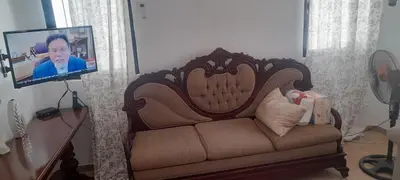 a living room with a couch and a tv at SDQ Villa Isabel, NO FUMAR, cerca embajada EEUU in Santo Domingo