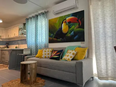 a living room with a couch and a painting on the wall at EL TOUCAN, Apartament in bayahibe in Bayahibe