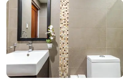 a bathroom with a sink and a toilet and a mirror at Condo Apartment in Ciudad Nueva