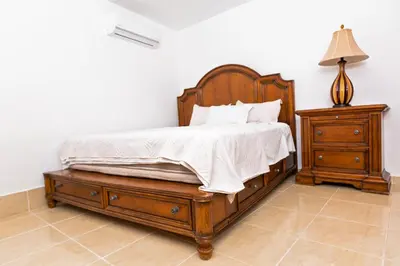 a bedroom with a wooden bed and a night stand at Villa Zapata - Apartamentos Turísticos in San Cristóbal