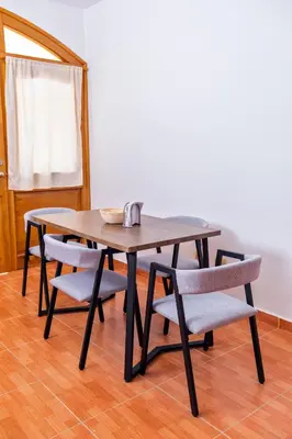 a wooden table with chairs and a wooden floor at Villa Zapata - Apartamentos Turísticos in San Cristóbal