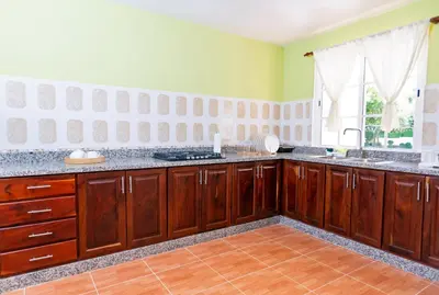 a large kitchen with wooden cabinets and a window at Villa Zapata - Apartamentos Turísticos in San Cristóbal